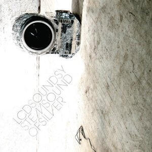 Worn black camera on a textured surface with the text 'LCD SOUNDSYSTEM SOUND OF SILVER' in thin uppercase letters.